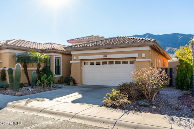 view of front of house with a tile roof, a garage, driveway, and stucco siding