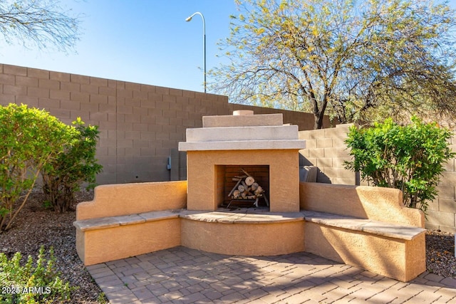 view of patio featuring a fenced backyard and an outdoor fireplace