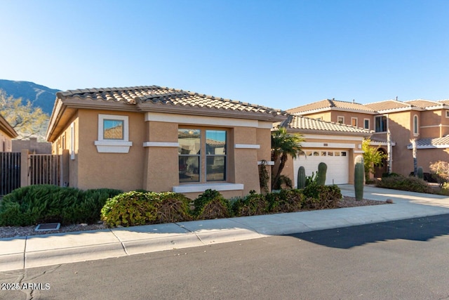 view of front of property featuring fence, stucco siding, concrete driveway, a garage, and a tiled roof