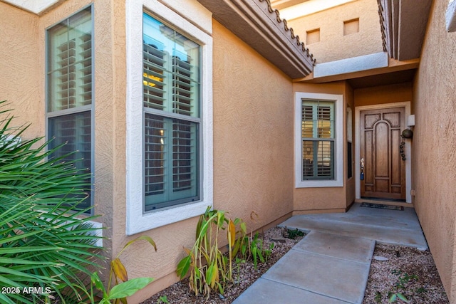 doorway to property featuring stucco siding