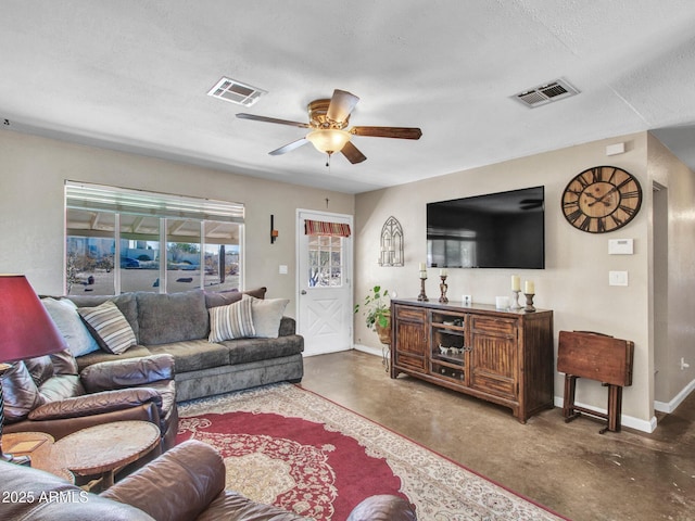 living area featuring finished concrete flooring, baseboards, visible vents, and a ceiling fan