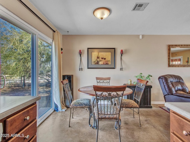 dining room featuring finished concrete floors, visible vents, and baseboards