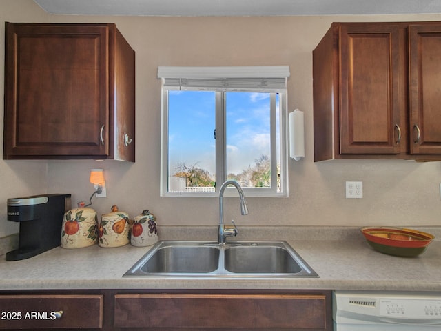 kitchen with light countertops, dishwasher, and a sink