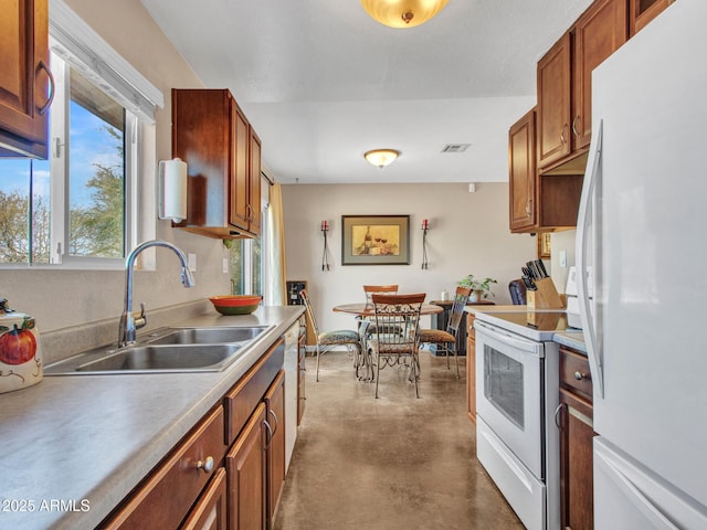 kitchen featuring finished concrete flooring, white appliances, visible vents, brown cabinets, and a sink