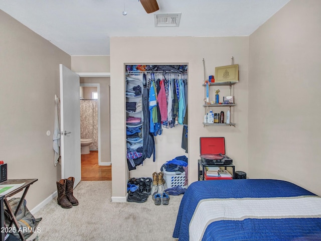 carpeted bedroom with a ceiling fan, a closet, visible vents, and baseboards