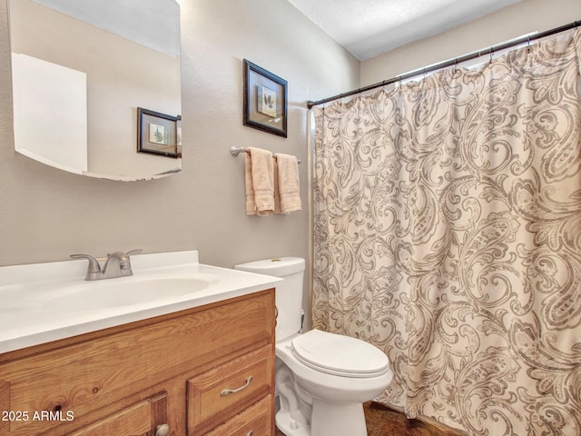 bathroom featuring toilet, curtained shower, and vanity