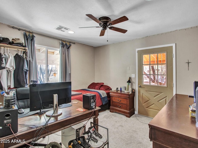 carpeted bedroom featuring a textured ceiling, ceiling fan, and visible vents