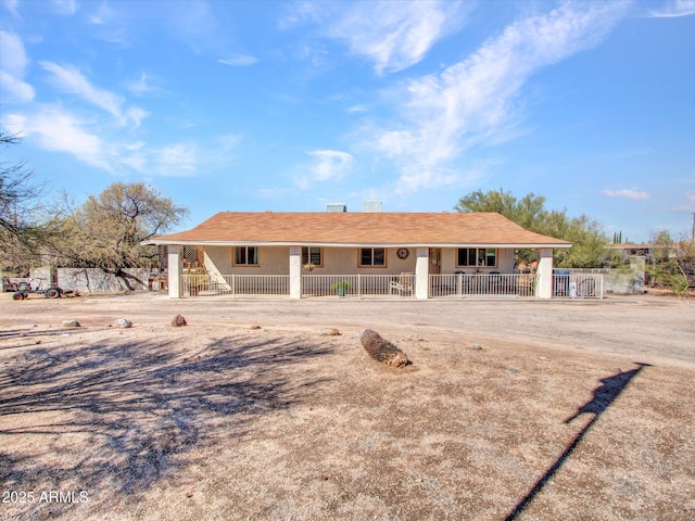 ranch-style home featuring fence