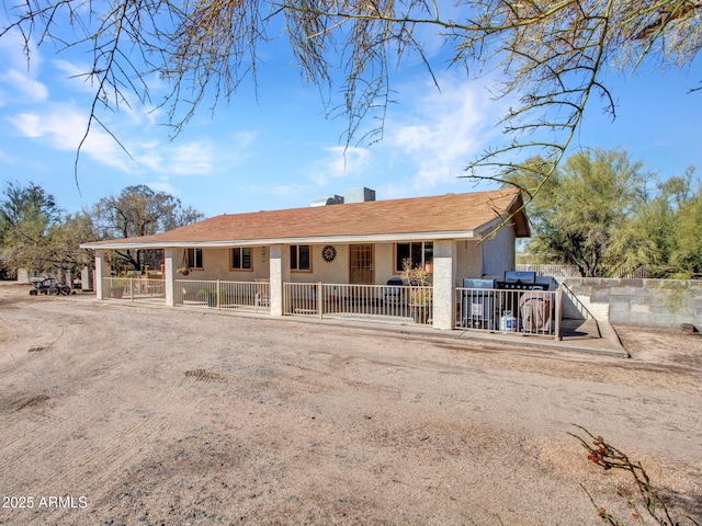 view of front facade with fence and stucco siding