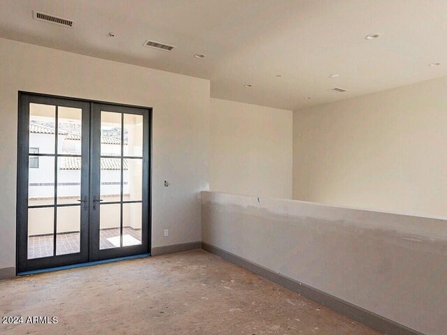 empty room with french doors, visible vents, and baseboards