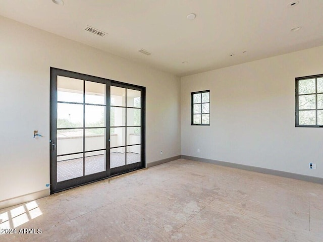 spare room with baseboards and visible vents