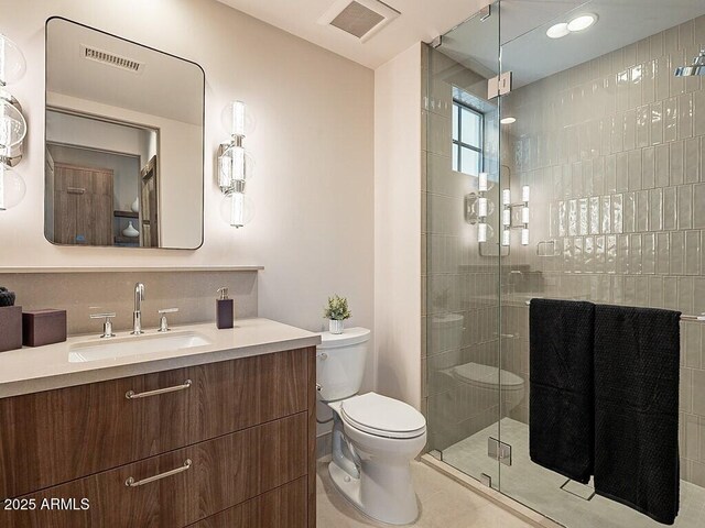 bathroom with toilet, a shower stall, visible vents, and vanity