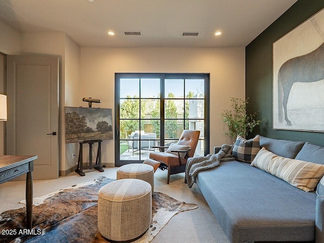 living area featuring carpet floors, recessed lighting, and visible vents