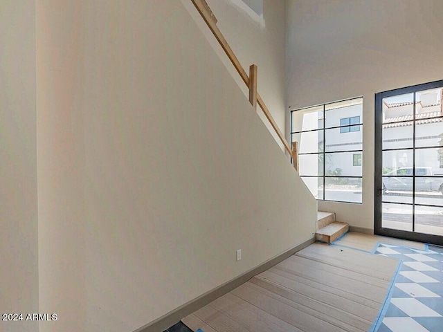 stairway featuring a towering ceiling