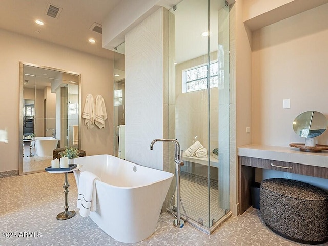 full bathroom with a stall shower, a freestanding tub, visible vents, and recessed lighting