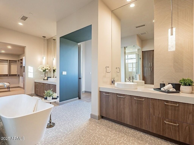 full bath featuring recessed lighting, a soaking tub, visible vents, and vanity