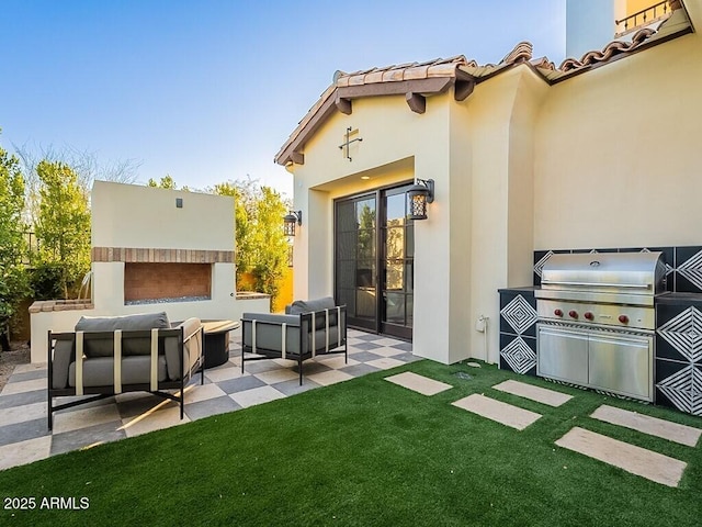 exterior space with an outdoor kitchen, a tiled roof, a patio area, an outdoor living space with a fireplace, and stucco siding