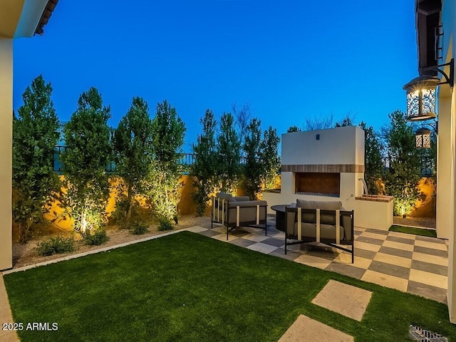 view of yard with a patio area, a fenced backyard, and an outdoor living space with a fireplace