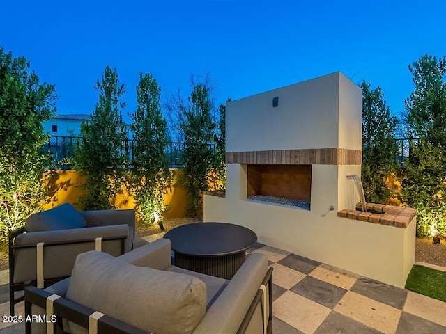 view of patio featuring an outdoor living space with a fireplace and a fenced backyard