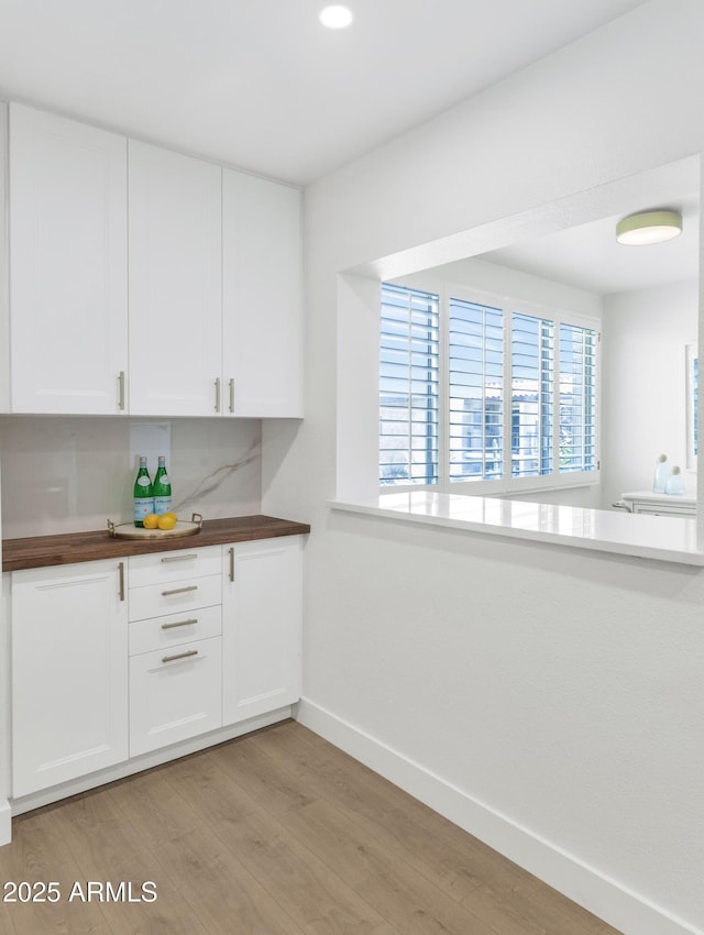4201 E Camelback Rd Unit 70, Phoenix, AZ 85018 - kitchen featuring baseboards, light wood finished floors, white cabinetry, wood counters, and recessed lighting