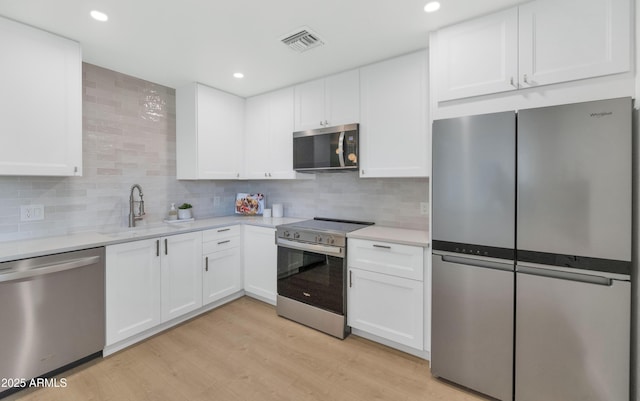 4201 E Camelback Rd Unit 70, Phoenix, AZ 85018 - kitchen featuring appliances with stainless steel finishes, a sink, light countertops, tasteful backsplash, and recessed lighting