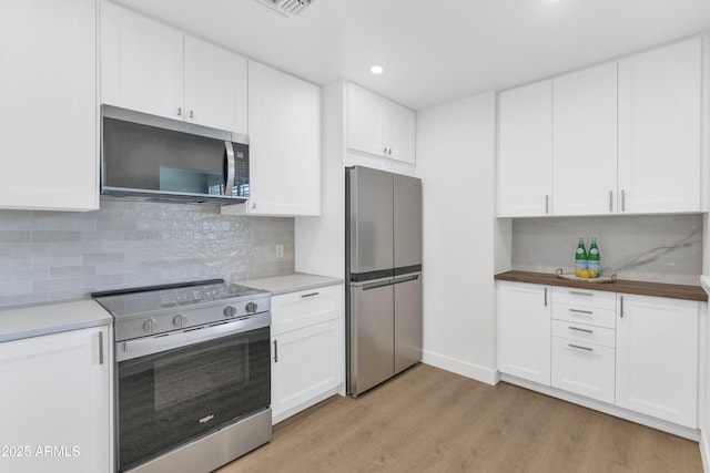 4201 E Camelback Rd Unit 70, Phoenix, AZ 85018 - kitchen with appliances with stainless steel finishes, light wood finished floors, white cabinetry, and recessed lighting