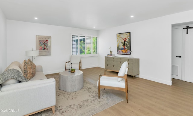 4201 E Camelback Rd Unit 70, Phoenix, AZ 85018 - living area with wood finished floors, a barn door, recessed lighting, and baseboards