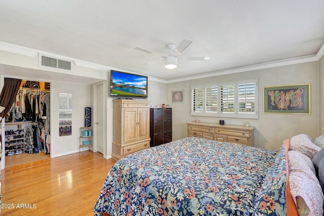 bedroom featuring ornamental molding, a ceiling fan, visible vents, and light wood-type flooring