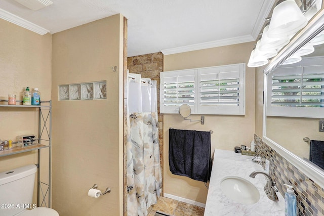 bathroom featuring crown molding, a sink, a shower with shower curtain, baseboards, and toilet
