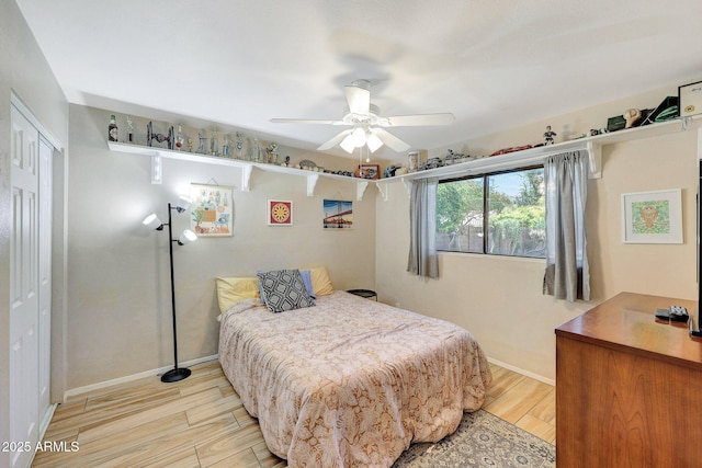 bedroom featuring a closet, ceiling fan, baseboards, and light wood-type flooring