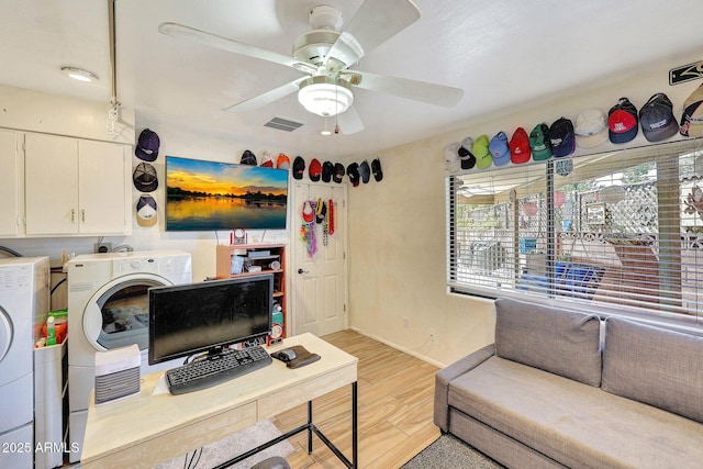 living area featuring visible vents, a ceiling fan, light wood-style flooring, and washing machine and dryer