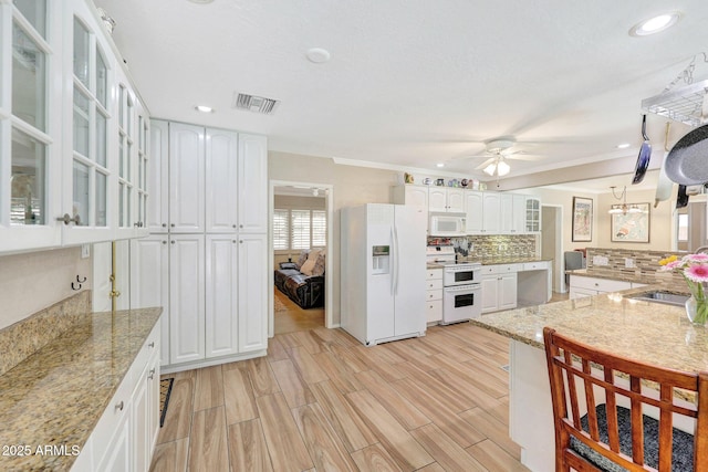 kitchen with glass insert cabinets, ceiling fan, tasteful backsplash, visible vents, and white appliances