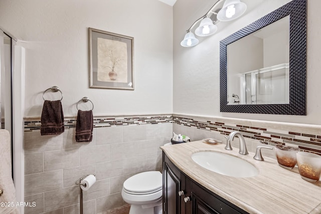 7342 E Norwood St, Mesa, AZ 85207 - bathroom featuring a stall shower, vanity, tile walls, toilet, and a wainscoted wall