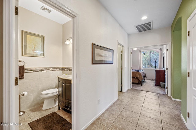 7342 E Norwood St, Mesa, AZ 85207 - ensuite bathroom with vanity, tile patterned flooring, toilet, wainscoting, and tile walls