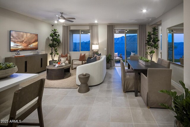 tiled living room featuring a water and mountain view and ceiling fan