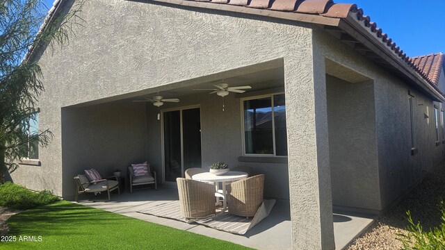 rear view of house featuring ceiling fan and a patio