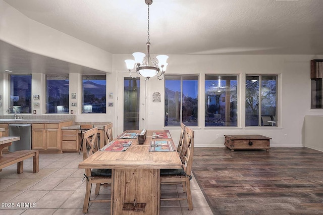 dining space featuring tile patterned flooring, a notable chandelier, and a textured ceiling