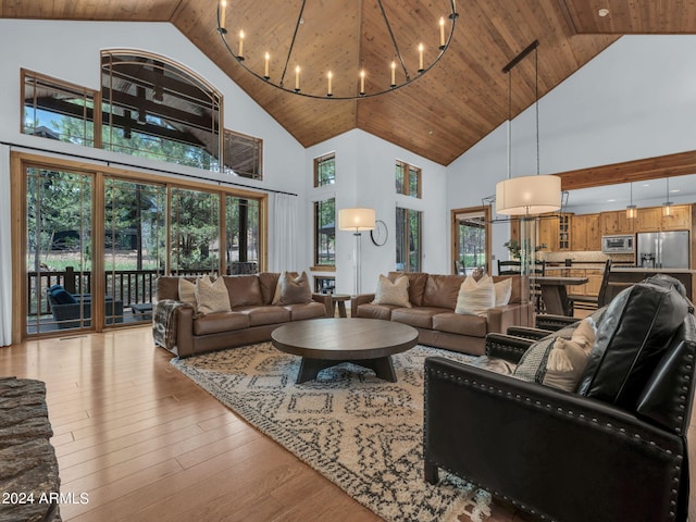 living room with light wood-type flooring, an inviting chandelier, wooden ceiling, and high vaulted ceiling