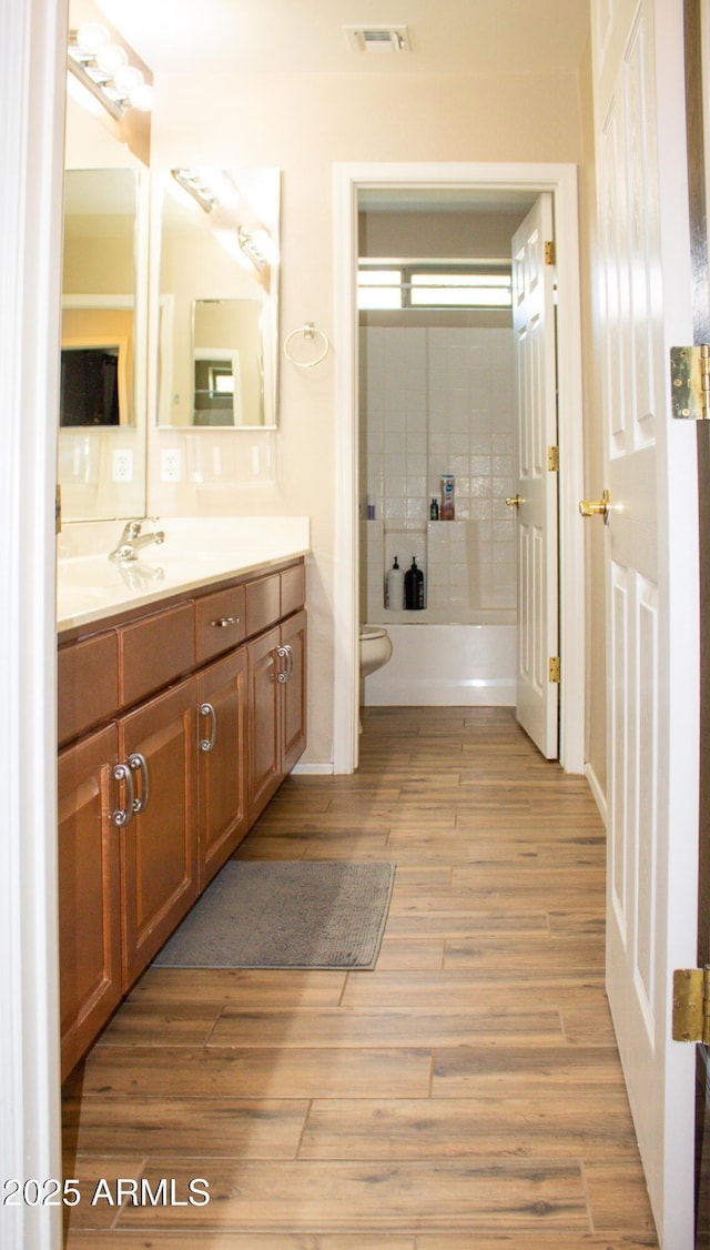 15148 W Sells Dr, Goodyear, AZ 85395 - bathroom featuring vanity, toilet, wood finished floors, and tub / shower combination