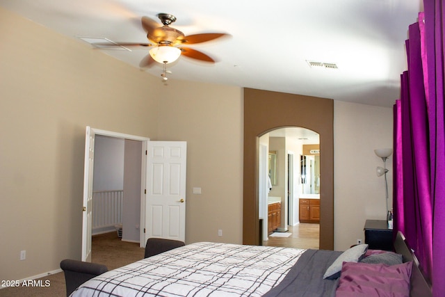 15148 W Sells Dr, Goodyear, AZ 85395 - bedroom featuring arched walkways, baseboards, light colored carpet, and ensuite bathroom