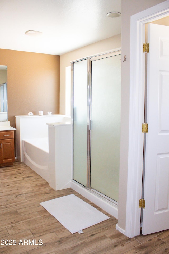 15148 W Sells Dr, Goodyear, AZ 85395 - bathroom featuring vanity, a stall shower, wood finished floors, and a garden tub