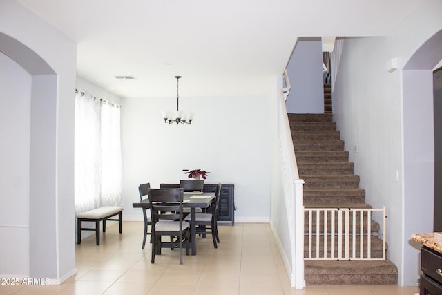 15148 W Sells Dr, Goodyear, AZ 85395 - dining space featuring arched walkways, stairway, a chandelier, and baseboards