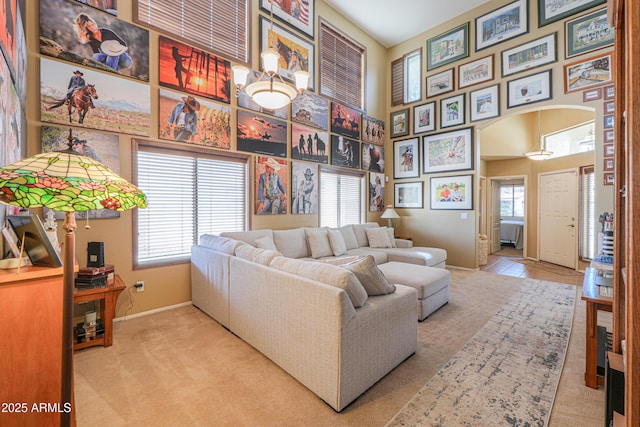 44890 W Desert Garden Rd, Maricopa, AZ 85139 - living room with arched walkways, a high ceiling, carpet flooring, and baseboards