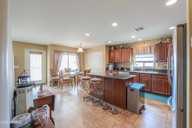 44890 W Desert Garden Rd, Maricopa, AZ 85139 - kitchen featuring freestanding refrigerator, a kitchen island, brown cabinetry, white dishwasher, and recessed lighting