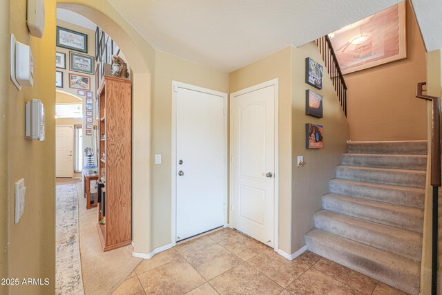 44890 W Desert Garden Rd, Maricopa, AZ 85139 - foyer with arched walkways, baseboards, stairway, and light tile patterned floors