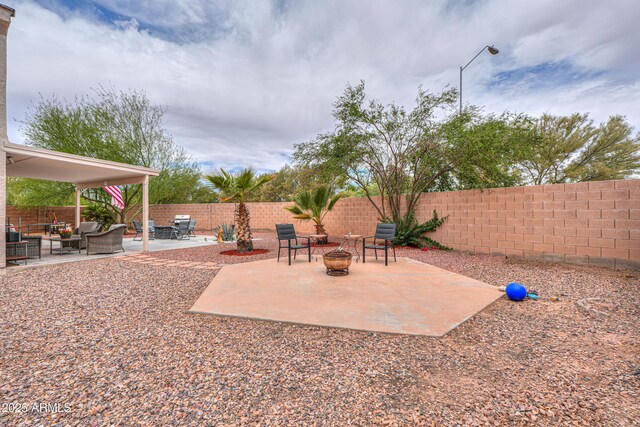44890 W Desert Garden Rd, Maricopa, AZ 85139 - fenced backyard featuring a patio and an outdoor living space with a fire pit