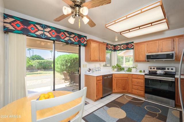 kitchen featuring sink, appliances with stainless steel finishes, light tile patterned flooring, and plenty of natural light