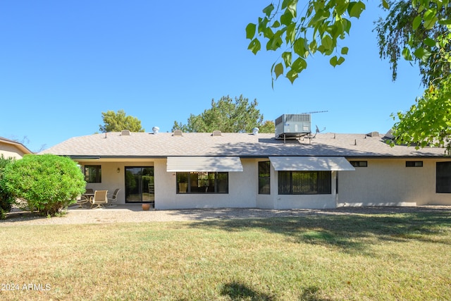 rear view of house featuring a yard, a patio, and central AC unit