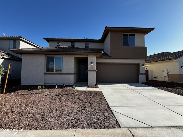 view of front of house featuring stucco siding, a garage, concrete driveway, and a tile roof