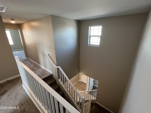 stairs with visible vents, baseboards, and carpet